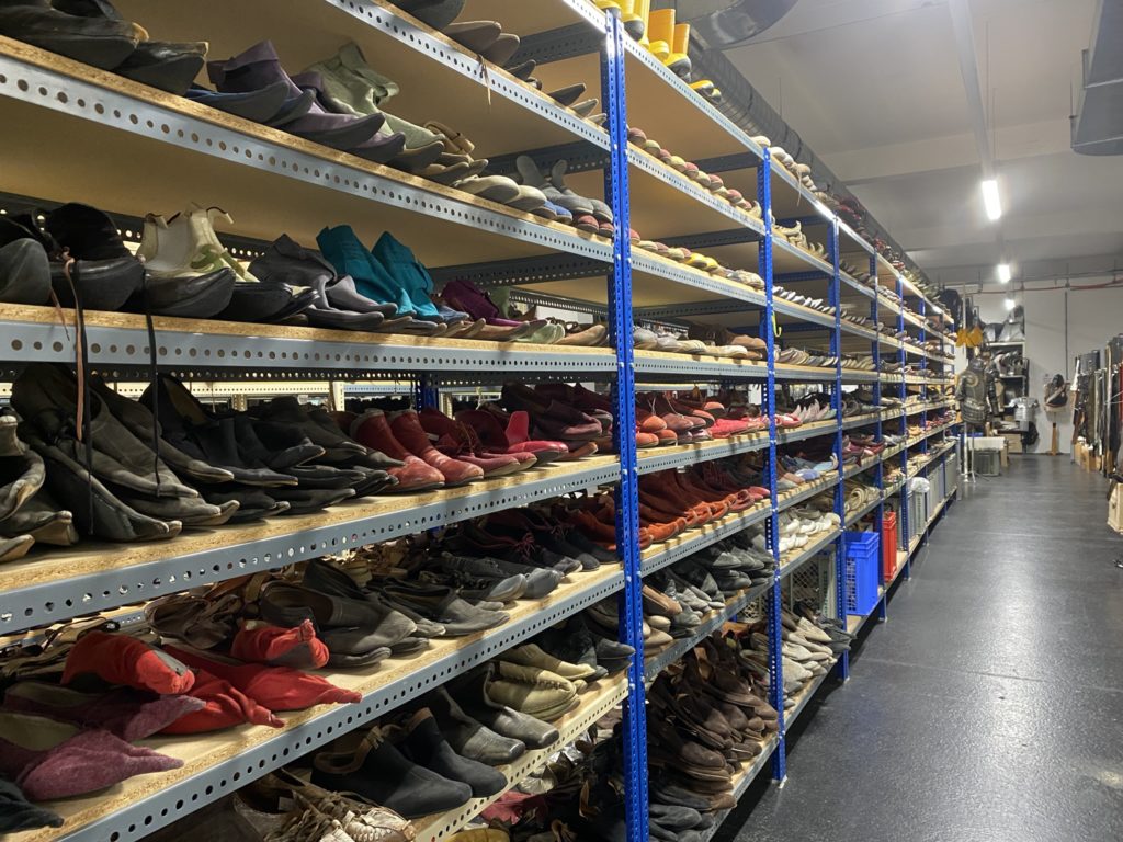 Regale voller verschiedener Schuhe in vielen Farben und Stilen stehen ordentlich in einem großen Lagerraum.